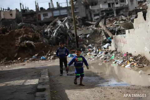 Palestinian boys walk past the ruins of a house that witnesses said was destroyed by Israeli shelling during the most recent conflict between Israel and Hamas, on a rainy day in the east of Gaza City November 3, 2014. Ph...