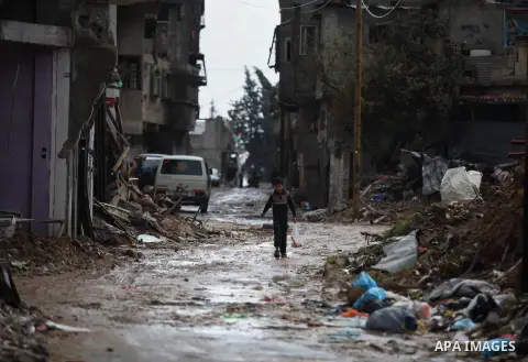 A Palestinian boy walks past the ruins of a house that witnesses said was destroyed by Israeli shelling during the most recent conflict between Israel and Hamas, on a rainy day in the east of Gaza City November 3, 2014....