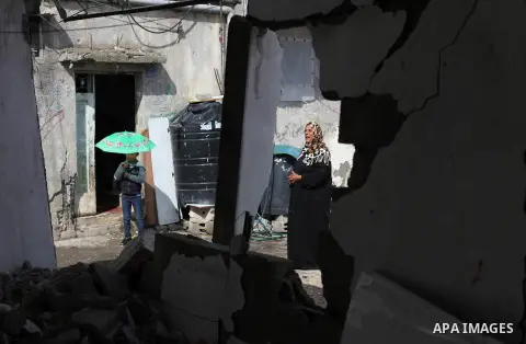 A Palestinian woman stands near the ruins of a house that witnesses said was destroyed by Israeli shelling during the most recent conflict between Israel and Hamas, on a rainy day in the east of Gaza City November 3, 201...