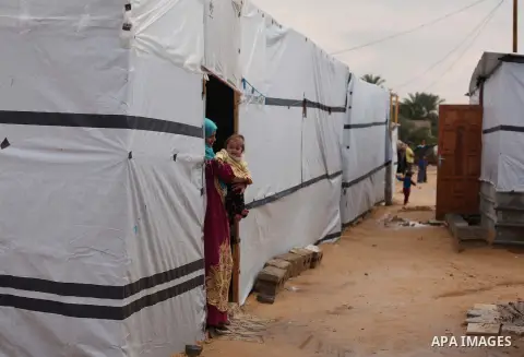 A Palestinian woman who lives in a container as a temporary replacement for her house that witnesses said was destroyed by Israeli shelling during the most recent conflict between Israel and Hamas, stands outside her con...
