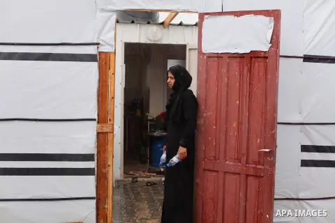 A Palestinian woman who lives in a container as a temporary replacement for her house that witnesses said was destroyed by Israeli shelling during the most recent conflict between Israel and Hamas, stands outside her con...
