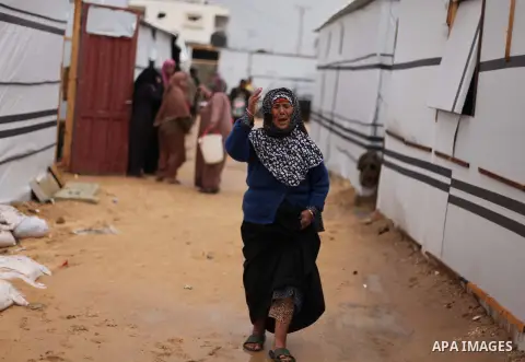 A Palestinian woman who lives in a container as a temporary replacement for her house that witnesses said was destroyed by Israeli shelling during the most recent conflict between Israel and Hamas, walks between containe...