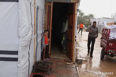 A Palestinian man who lives in a container as a temporary replacement for hi house that witnesses said was destroyed by Israeli shelling during the most recent conflict between Israel and Hamas, walks between containers...