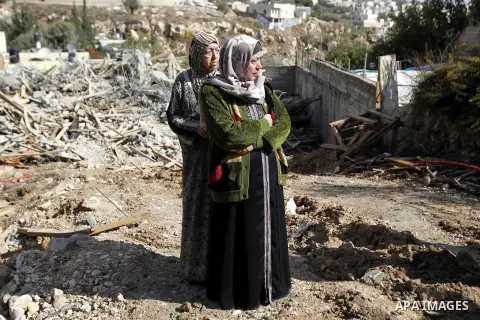 Palestinian Um Issam (front) stands with a relative near the rubble of her demolished house in the East Jerusalem neighbourhood of Abu Tor November 4, 2014. Israeli forces demolished two Palestinian homes on Tuesday in t...