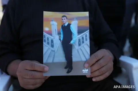 Grandfather of Hammam Hammam Masalma, the suspect in hit-and-run that left three soldiers injured, holds Hammam's picture, at his house in Beit Awwa, near the West Bank city of Hebron, November 6, 2014. The hit-and-run i...