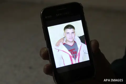 The mother of Palestinian Nur al-Din Abu Hashi shows a picture of her son in a mobile phone, at Askar refugee camp near the West Bank city, on Nov. 11, 2014. According to Israeli media, the suspect is a Nablus resident w...