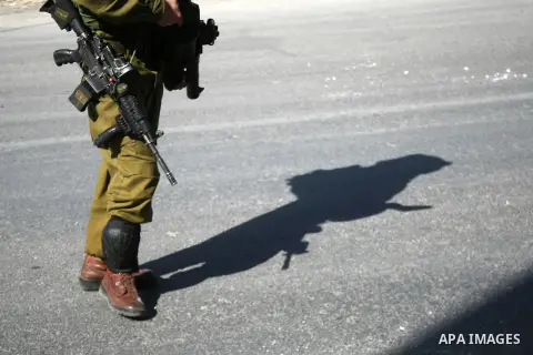 An Israeli soldier takes position during clashes with Palestinian protester on the outskirts of the West Bank city of Hebron on November 11, 2014. Clashes erupted as Israeli soldiers shot and killed 22 year-old Palestini...