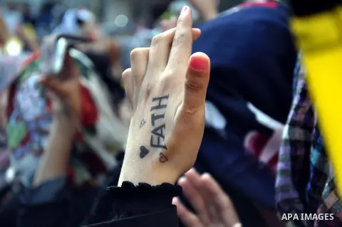 A female supporter of the Palestinian Fatah movement shows her hand tattoo during a rally marking the tenth anniversary of late Palestinian leader and founder of the movement Yasser Arafat in front of the Al-Azhar Univer...