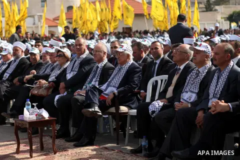 Palestinian president Mahmud Abbas (C) sits next to Palestinian prime minister Rami Hamdallah (L), during a ceremony to mark the tenth anniversary of the death of late Palestinian leader Yasser Arafat in the West Bank ci...