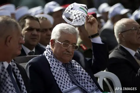 Palestinian president Mahmud Abbas (C) sits next to Palestinian prime minister Rami Hamdallah (L), during a ceremony to mark the tenth anniversary of the death of late Palestinian leader Yasser Arafat in the West Bank ci...