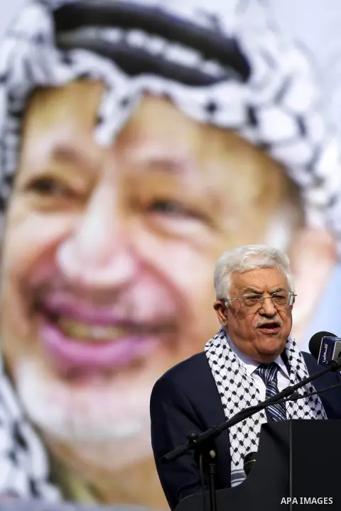 Palestinian president Mahmud Abbas delivers a speech during a ceremony marking 10 years since the death of veteran leader Yasser Arafat (portrait in the background) in the West Bank city of Ramallah on November 11, 2014....