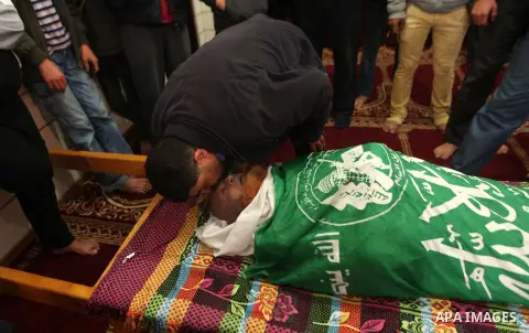 Palestinians mourn around the body of a co-founder of the Hamas movement Mohammad Salih Taha during his funeral in al-Bureij refugee camp in the central of Gaza strip, on Nov. 12, 2014. Taha, often called Abu Ayman, was...