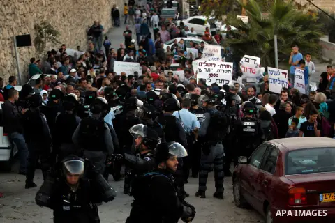 Palestinian protesters hold placards in front of Israeli border police, during a demonstration at the east Jerusalem Arab neighborhood of Issawiya, 12 November 2014. Israel has beefed up security following two recent fat...
