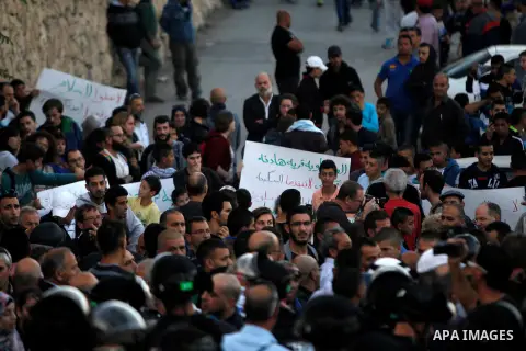 Palestinian protesters hold placards in front of Israeli border police, during a demonstration at the east Jerusalem Arab neighborhood of Issawiya, 12 November 2014. Israel has beefed up security following two recent fat...