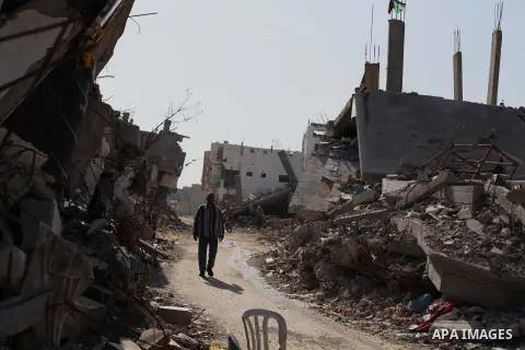 A Palestinian man walks past the rubble of homes which were destroyed during the 50-day Gaza war between Israel and Hamas-led militants in the Gaza Strip, at Shijaiya neighbourhood, in Gaza city on November 13, 2014. The...