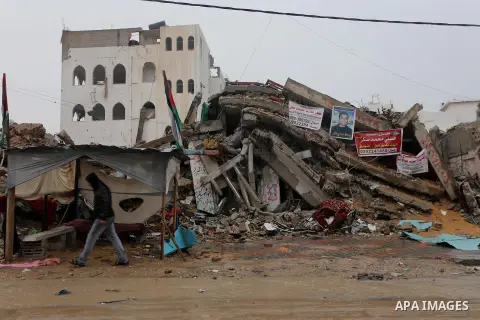 A Palestinian man walks past a house that witnesses said was destroyed by Israeli shelling during the most recent conflict between Israel and Hamas, on a rainy day in the east of Gaza City November 16, 2014. Photo by Moh...