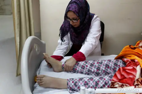 Nedaa Abu Daqqa, 20, a wounded Palestinian girl receives therapy treatment, at a hospital in Khan Younis, in the southern Gaza Strip, November 17, 2014. Abu Daqqa suffers from hemiplegia after she was injured in spine du...