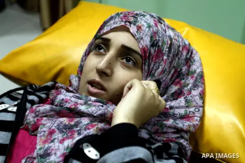 Nedaa Abu Daqqa, 20, a wounded Palestinian girl speaks to phone as she receive therapy treatment, at a hospital in Khan Younis, in the southern Gaza Strip, November 17, 2014. Abu Daqqa suffers from hemiplegia after she w...