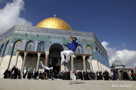 Palestinian youths practice parkour outside the Dome of the Rock mosque at the Al-Aqsa mosque compound following Friday prayers in the Old City of Jerusalem on November 21, 2014. Israel eased age restrictions for Friday...