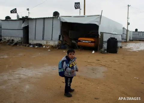 A Palestinian school child stand on a rainy day past the temporary homes of Palestinian that witnesses said was destroyed by Israeli shelling during the most recent conflict between Israel and Hamas in Khan Younis in the...