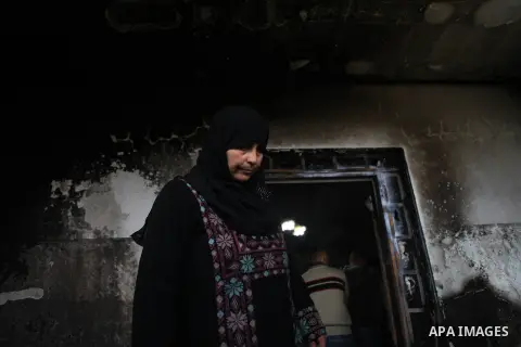 A member of the Hamayel family inspects the damage to her home, that was attacked and burnt by suspected Jewish extremists using petrol bombs, in the village of Abu Falah, northeast of Ramallah, on November 23, 2014. Sus...