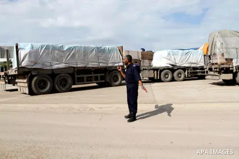 A Palestinian policeman walks past trucks loaded with cement that entered the Gaza Strip from Israel through the Kerem Shalom crossing in Rafah in the southern Gaza Strip on November 25, 2014. Twenty-eight trucks of ceme...