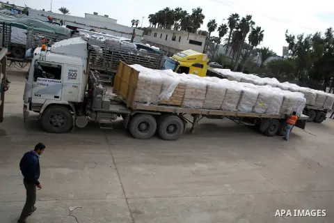 A Palestinian worker walks past trucks loaded with cement that entered the Gaza Strip from Israel through the Kerem Shalom crossing in Rafah in the southern Gaza Strip on November 25, 2014. Twenty-eight trucks of cement...