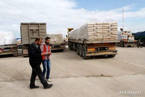 A Palestinian policeman walks past trucks loaded with cement that entered the Gaza Strip from Israel through the Kerem Shalom crossing in Rafah in the southern Gaza Strip on November 25, 2014. Twenty-eight trucks of ceme...