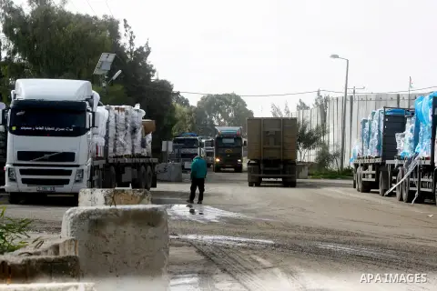 A Palestinian worker walks past trucks loaded with cement that entered the Gaza Strip from Israel through the Kerem Shalom crossing in Rafah in the southern Gaza Strip on November 25, 2014. Twenty-eight trucks of cement...