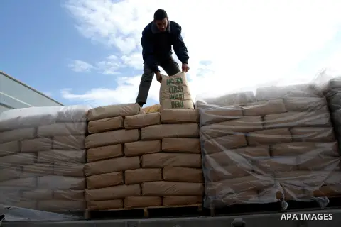 A Palestinian worker adjusts bags of cement loaded on a truck that entered the Gaza Strip from Israel through the Kerem Shalom crossing in Rafah in the southern Gaza Strip on November 25, 2014. Twenty-eight trucks of cem...