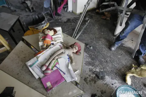 A worker inspects the damage on the aftermath of an arson attack that targeted first-grade classrooms at a Jewish-Arab school near the Arab neighborhood of Beit Safafa, in southern Jerusalem, on November 30, 2014. Scrawl...