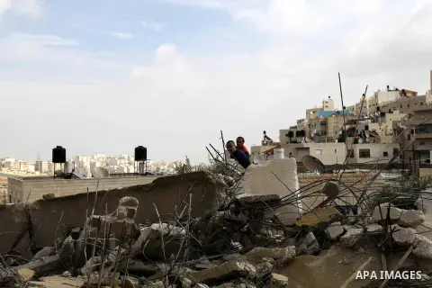 Palestinians stand on the rubble of their house that was demolished by Jerusalem municipality workers in the east Jerusalem neighbourhood of Issawiya, December 1, 2014. Palestinian homes built without an Israeli construc...