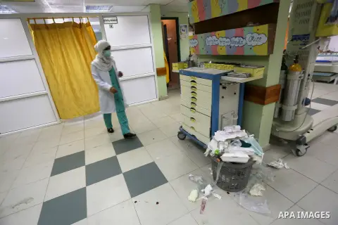 A Palestinian employee of the former government in Gaza Strip works at al-shifa hospital as clean workers protest to demand for pay their salaries, in Gaza City December 4, 2014. Photo by Mohammed Asad
