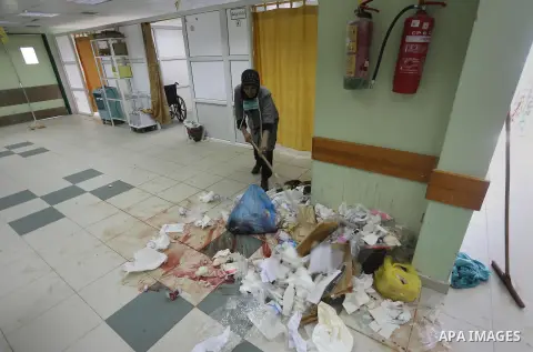 A Palestinian employee of the former government in Gaza Strip works at al-shifa hospital as clean workers protest to demand for pay their salaries, in Gaza City December 4, 2014. Photo by Mohammed Asad