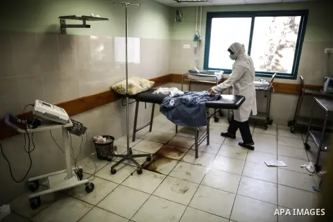A Palestinian doctor of the former government in Gaza Strip works at al-shifa hospital as clean workers protest to demand for pay their salaries, in Gaza City December 4, 2014. Photo by Ali Jadallah
