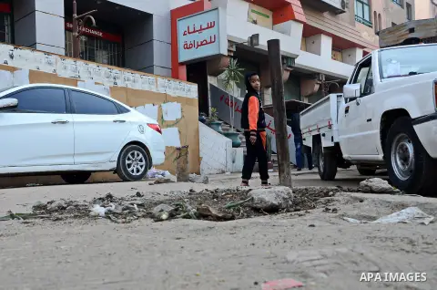 An Egyptian boy stands watch at the scene after defused a bomb by civil protection forces in al-Haram street, near Cairo, December 5, 2014. Photo by Amr Sayed