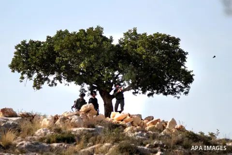 A member of Israeli security forces fires tear gas towards Palestinian protesters during clashes following a demonstration against Israel's controversial barrier, in the outskirts of the village of Bilin, near the West B...