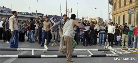 A Egyptian protester uses his shoe against a pro-regime supporter during a demonstration denouncing a recent court's decision to drop a murder charge against the former president, on December 5, 2014, on Abdel Moneim Ria...