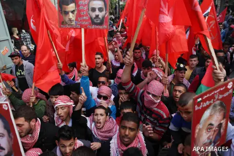 Palestinian supporters of the Popular Front for the Liberation of Palestine hold national flags during a rally to celebrate the 46th anniversary of its founding in the West Bank city of Ramallah, December 6, 2014. Photo...