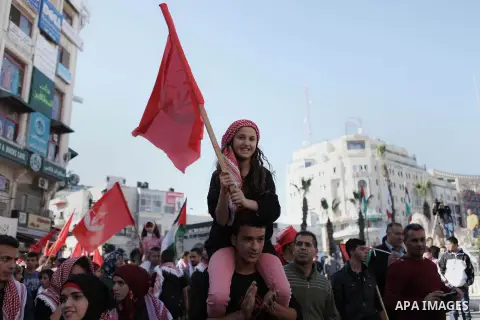 Palestinian supporters of the Popular Front for the Liberation of Palestine hold national flags during a rally to celebrate the 46th anniversary of its founding in the West Bank city of Ramallah, December 6, 2014. Photo...