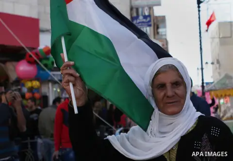 Palestinian supporters of the Popular Front for the Liberation of Palestine hold national flags during a rally to celebrate the 46th anniversary of its founding in the West Bank city of Ramallah, December 6, 2014. Photo...