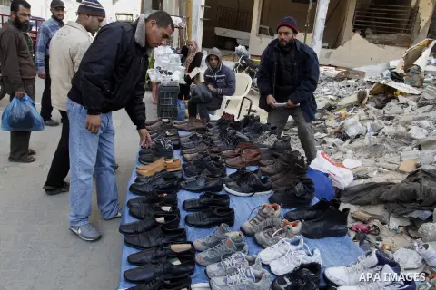 Palestinians looks at second hand shoes at a market in Rafah in the southern Gaza strip, December 06, 2014. Due to the current economic situation in Gaza Strip, many of the Palestinians resort to meet their needs of used...
