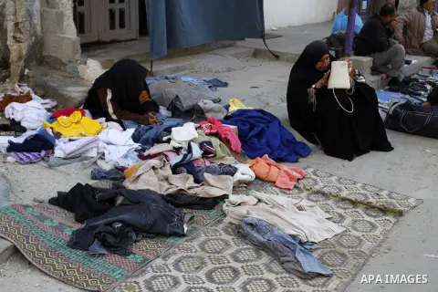 Palestinians looks at second hand clothes at a market in Rafah in the southern Gaza strip, December 06, 2014. Due to the current economic situation in Gaza Strip, many of the Palestinians resort to meet their needs of us...
