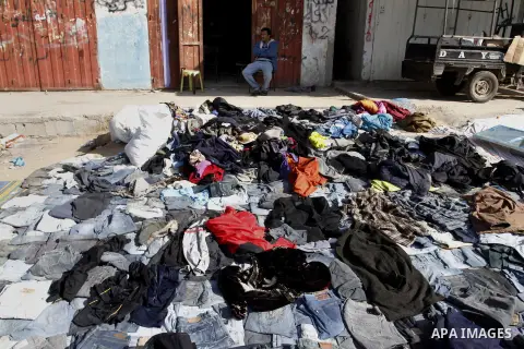Palestinians looks at second hand shoes at a market in Rafah in the southern Gaza strip, December 06, 2014. Due to the current economic situation in Gaza Strip, many of the Palestinians resort to meet their needs of used...