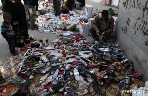 Palestinians looks at second hand shoes at a market in Rafah in the southern Gaza strip, December 06, 2014. Due to the current economic situation in Gaza Strip, many of the Palestinians resort to meet their needs of used...