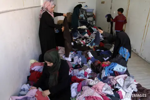 Palestinians looks at second hand clothes at a market in Rafah in the southern Gaza strip, December 06, 2014. Due to the current economic situation in Gaza Strip, many of the Palestinians resort to meet their needs of us...