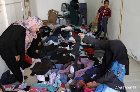 Palestinians looks at second hand clothes at a market in Rafah in the southern Gaza strip, December 06, 2014. Due to the current economic situation in Gaza Strip, many of the Palestinians resort to meet their needs of us...