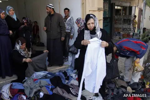 Palestinians looks at second hand clothes at a market in Rafah in the southern Gaza strip, December 06, 2014. Due to the current economic situation in Gaza Strip, many of the Palestinians resort to meet their needs of us...