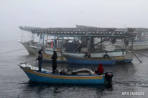 Palestinian fishermen ride their fishing boat at the seaport of Gaza City on December 7, 2014. Israeli forces detained 12 Palestinian fishermen off the coast of the northern Gaza Strip early Sunday. Photo by Mohammed Asa...