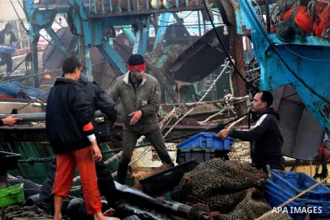 Palestinian fishermen ride their fishing boat at the seaport of Gaza City on December 7, 2014. Israeli forces detained 12 Palestinian fishermen off the coast of the northern Gaza Strip early Sunday. Photo by Mohammed Asa...